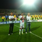 Neto Pereira giura con la mano sul cuore. Striscione della squadra verso la Nord