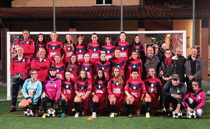 Gruppo di tre calciatori femminili che si rilassano sul campo. Le